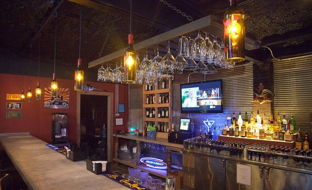 The bar at Hoots: corrugated tin walls, pendant lights made from bottles and a long counter