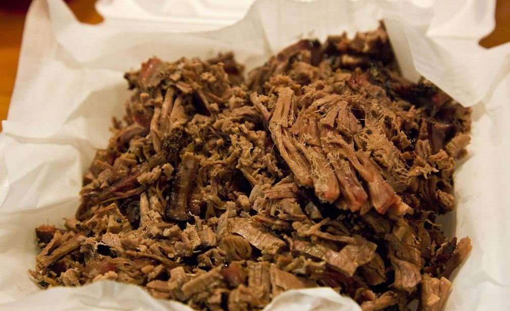 A pile of chopped smoked beef brisket in a paper-lined basket