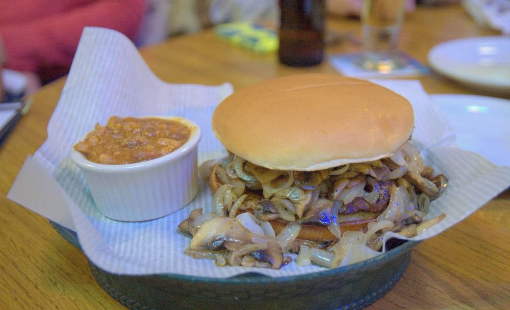 A mushroom Swiss burger with a side of baked beans