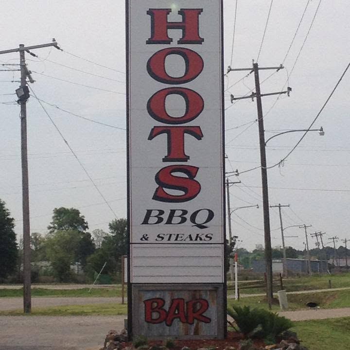 The tall roadside sign: HOOTS BBQ & Steaks, with a rusty BAR panel below