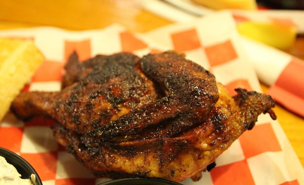 Half a smoked chicken with a dark peppery rub